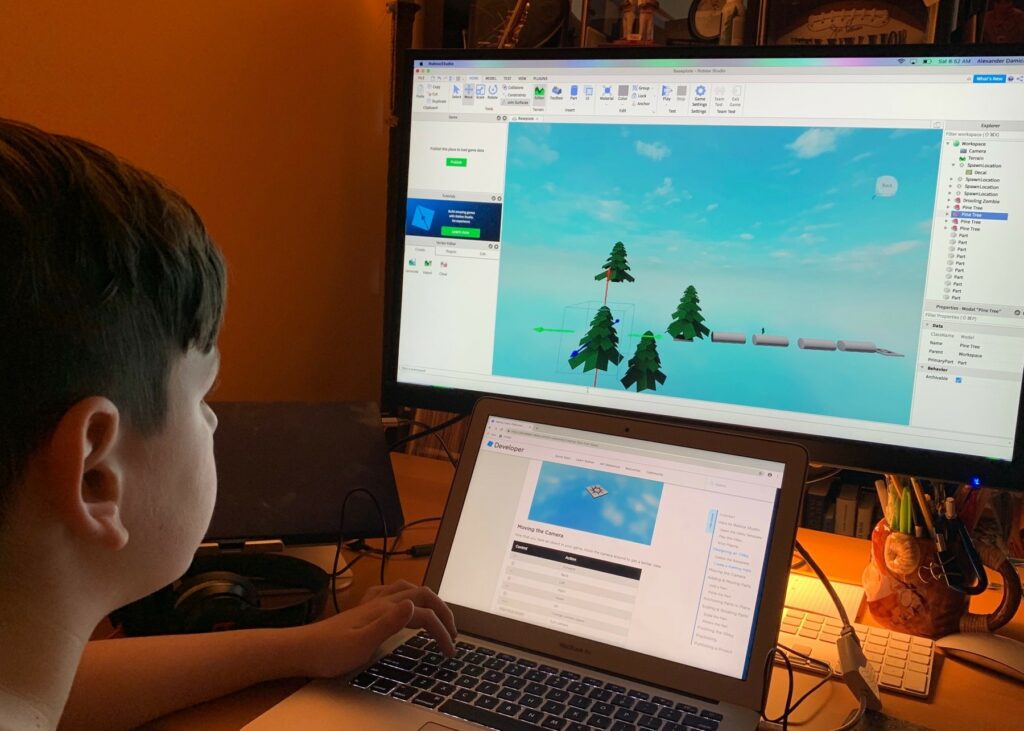 [A young boy (my son) working in Roblox Studio